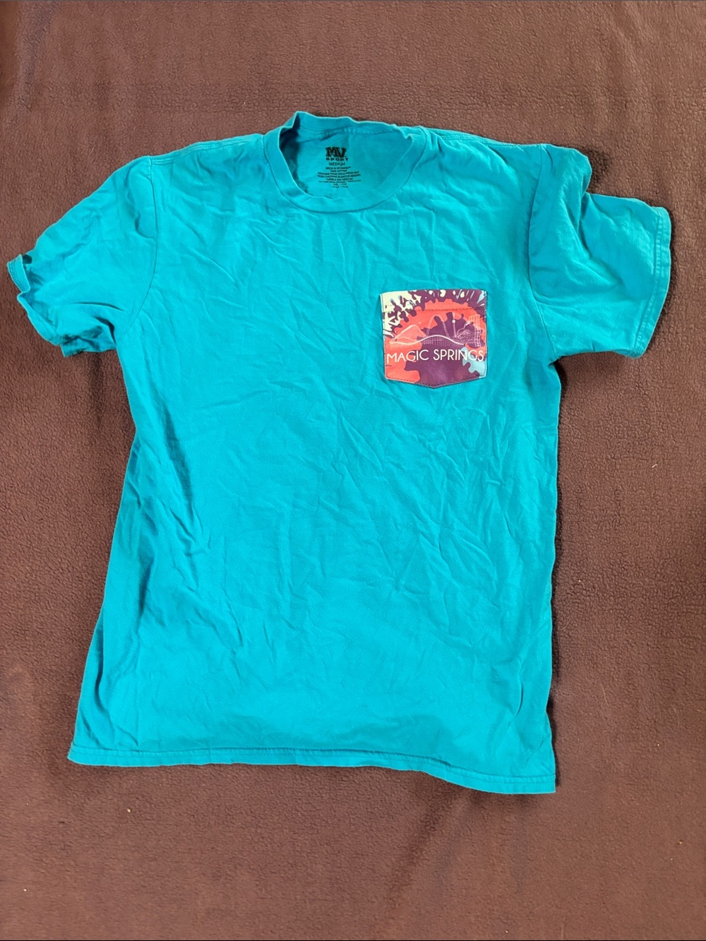 Teal Magic Springs shirt on pocket